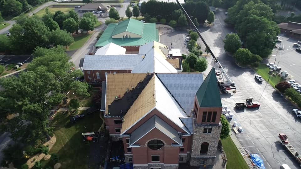 aerial photo of roof with the last of the old roof being removed and the new underlay on the majority of the roof.