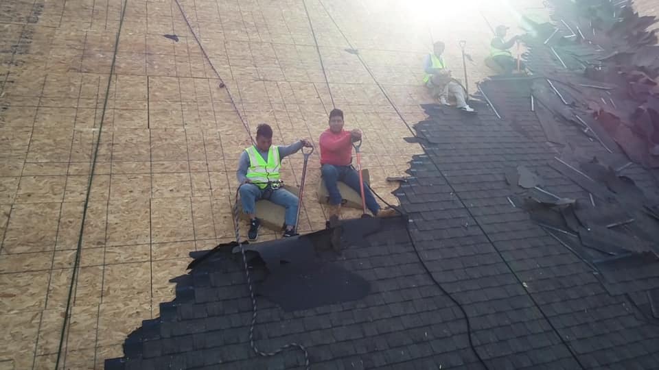 close up aerial photo of Ridgeline team on the roof at work removing the old roof