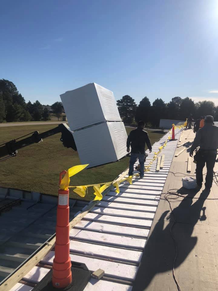 photo of roofing materials being loaded on the roof