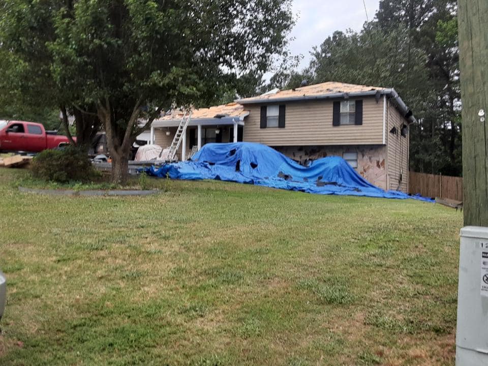 Photo of front of home undergoing roof replacement