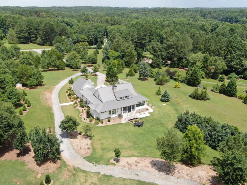 aerial view of the estate property with the home in a new metal roof