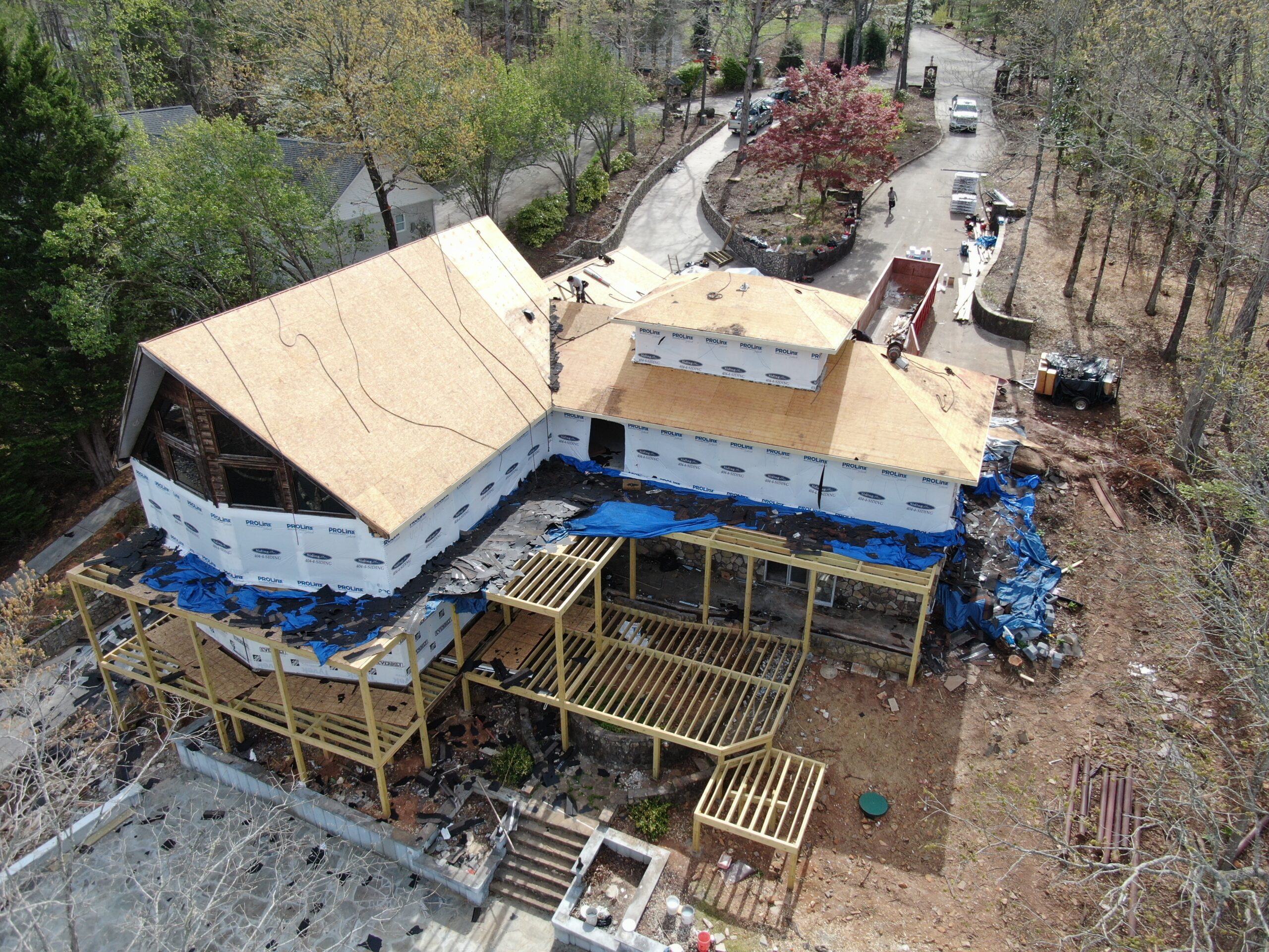 arial photo of rear of home showing the new timberframed great room windows and expansive 3 stories of decks being added