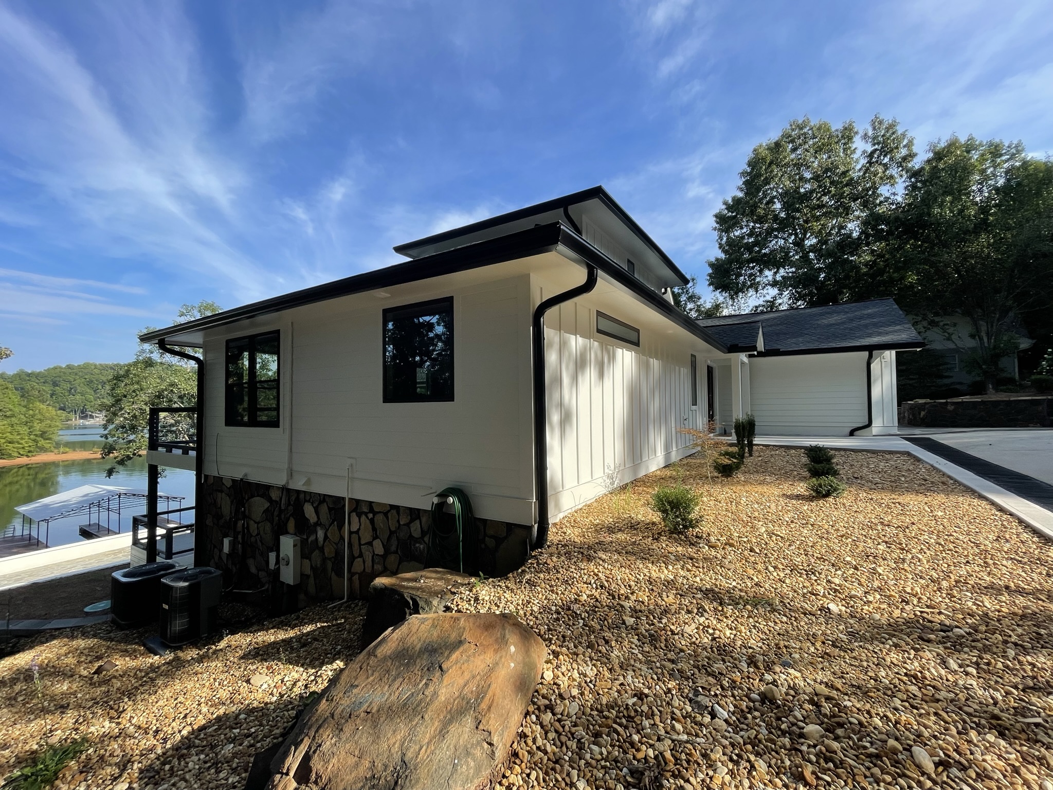 Photo of side of home showing the entrance to the garage and front of home with a view of the lake